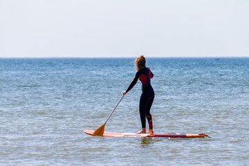 Fototapeta na wymiar Pratiquante de stand-up paddle à Stella-plage