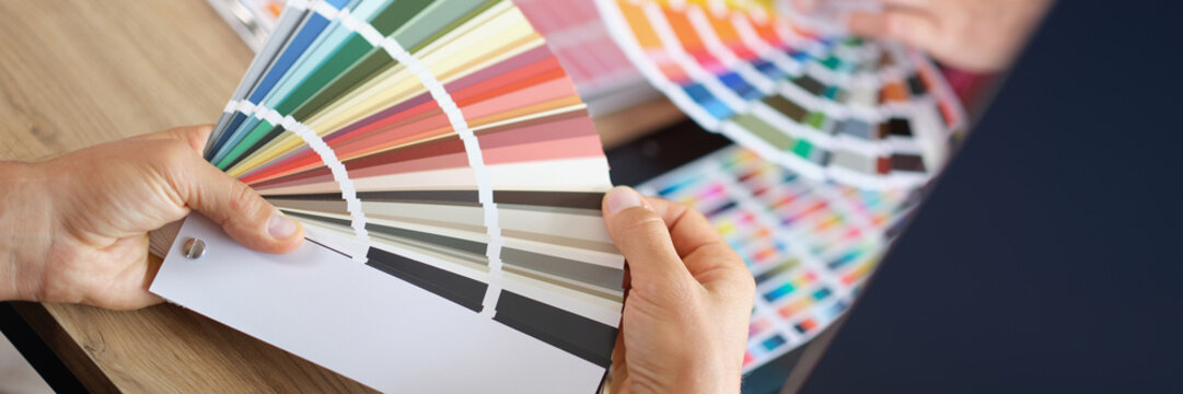Creative designer advises client and shows color sample in color palette