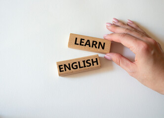 Learn English symbol. Wooden blocks with words Learn English. Businessman hand. Beautiful white background. Business and Learn English concept. Copy space.