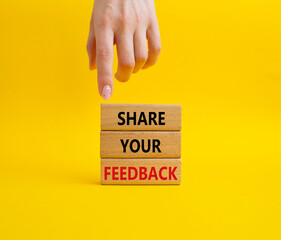 Feedback symbol. Concept word Share your feedback on wooden blocks. Businessman hand. Beautiful yellow background. Business and Ask for feedback concept. Copy space