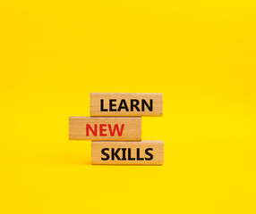 Learn new skills symbol. Concept words Learn new skills on wooden blocks. Beautiful yellow background. Business and Learn new skills concept. Copy space.