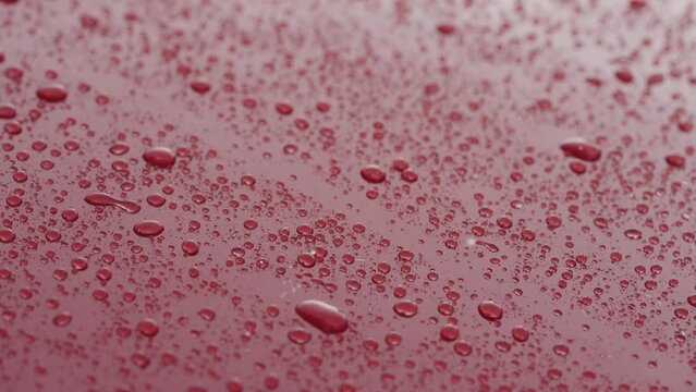 Slow motion of ceramic coated car under rain, water drops sliding from car