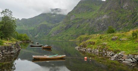 Summer view on a cloudy day of a mountain lake with rowboats on the Lofoten archipelago. the...