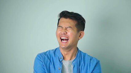 Asian man happy laughing standing on white background..