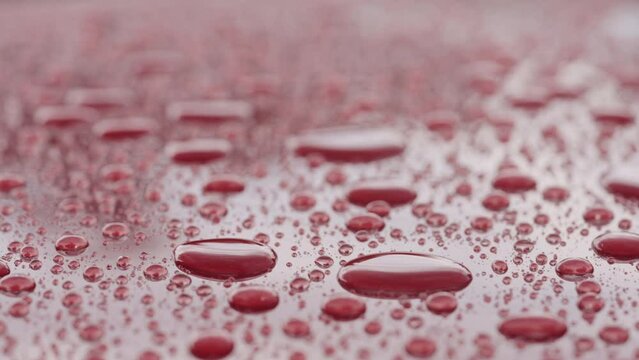 Slow motion of ceramic coated car under rain, water drops sliding from car