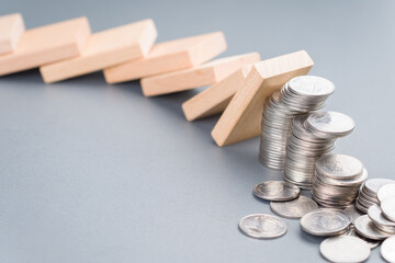 Domino effect impacts some of the heap of coins falling down, finance status, investment in domino...