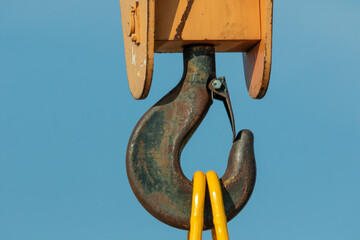 close up of gantry crane with hook against blue sky 
