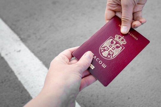 Giving a National passport of Serbia for a check on the boarder. No face, hands