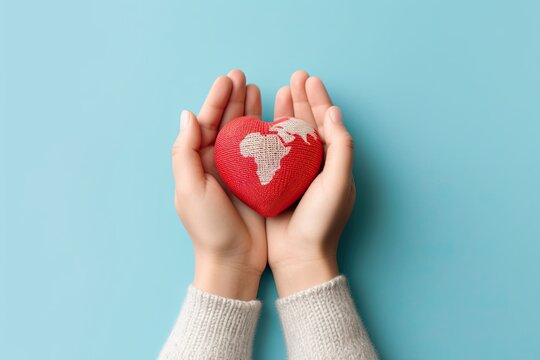 Woman hands holding red world map heart against blue background