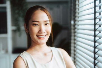 Portrait of Asian woman smiling while looking at camera.