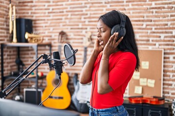 Young african american woman artist singing song at music studio