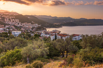 Fototapeta na wymiar forested hill top view to coastal town of Kas with white houses under tiled roofs at sunrise, Turkey
