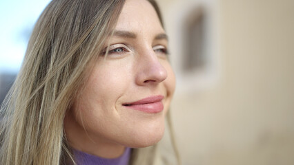 Young blonde woman smiling confident looking to the side at street