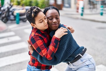 African american mother and son smiling confident hugging each other at street