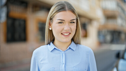 Young blonde woman business worker smiling confident standing at street