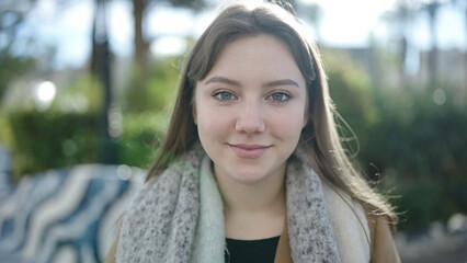 Young blonde woman smiling confident standing at park