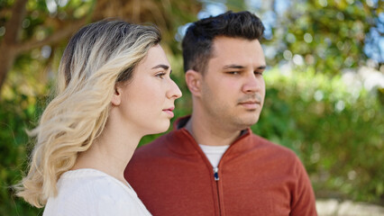 Man and woman couple standing together with relaxed expression at park