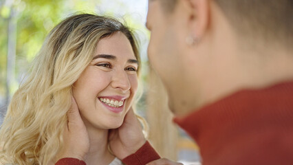 Man and woman couple smiling confident hugging each other at park