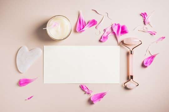 Set of face and neck skin care accessories on a pink background. Roller and gua sha rose quartz, mockup blank, copy space.