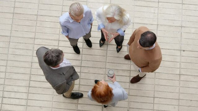 Group of business people talking standing in circle outdoors
