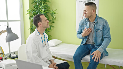 Two men doctor and patient speaking having medical consultation at clinic