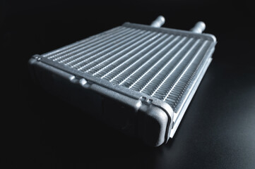 Spare background car radiator of the heating and air conditioning system, car stove radiator, black background close-up, selective focus.