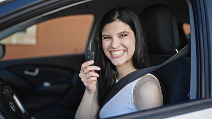 Fototapeta na wymiar Young beautiful hispanic woman smiling confident holding key of new car at street