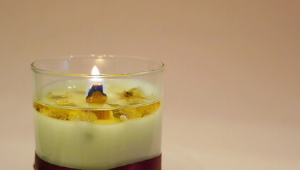Fragrant soft candle in a glass jar with a burning wooden wick
