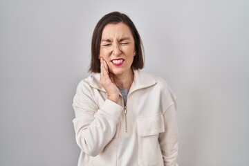 Middle age hispanic woman standing over isolated background touching mouth with hand with painful expression because of toothache or dental illness on teeth. dentist