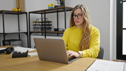 Young blonde woman business worker using laptop working at office