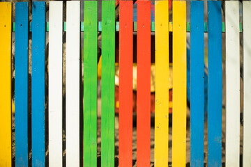 Colored fence. Beautiful fence. Different color on boards. Painted material.