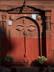 Door to a palace with face carved out of wood.