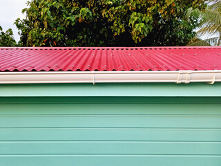 Close up of the facade of horizontal sheets, water pipes and Caribbean tin roof. Tropical...