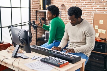 African american man and woman music group singing song playing keyboard piano at music studio