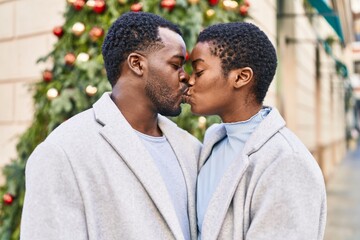 Man and woman couple standing together kissing at street