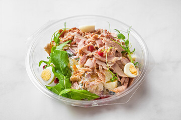 Plastic package with healthy baked ham salad for take away or food delivery on white background. Food in lunch box