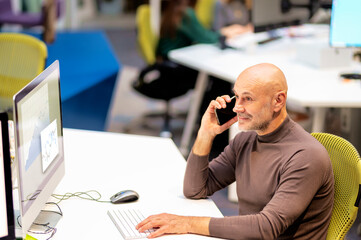 Financial assistant business man sitting at desk and making a call and using computer for work