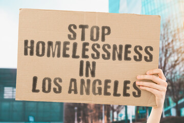 man's hand firmly grasps a banner that reads ' Stop Homelessness in Los Angeles '. plight of...