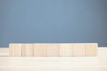 wood empty seven blocks on table and blue background with copy space for text or symbols, development concept for growth success process.