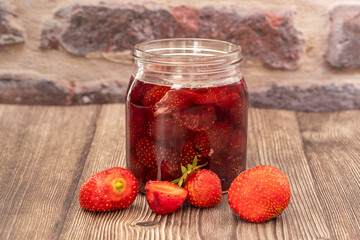 Homemade delicious strawberry jam and strawberry on a rustic wooden table