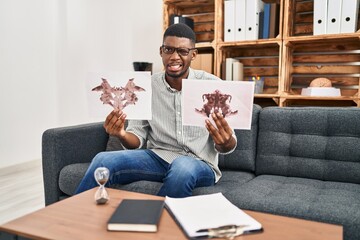 African american man working with rorschach test at psychology clinic clueless and confused...