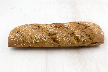 Delicious rye flour bread with seeds and vegetables in the form of a baguette.
