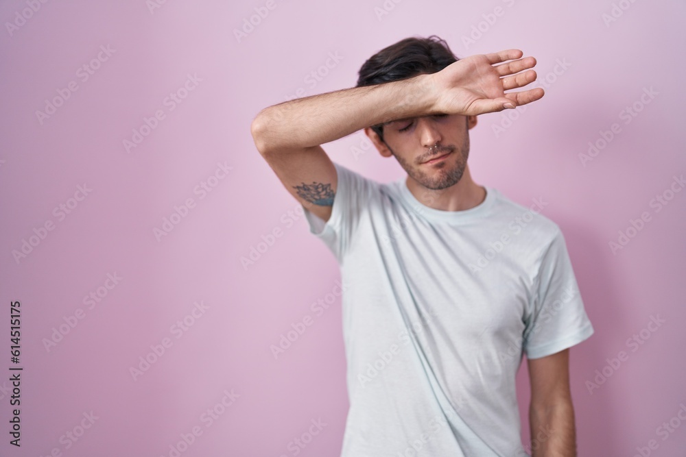 Canvas Prints Young hispanic man standing over pink background covering eyes with arm, looking serious and sad. sightless, hiding and rejection concept