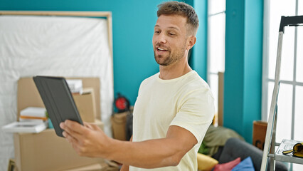 Young man using touchpad smiling at new home