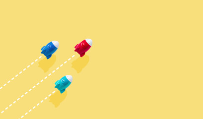 Red Blue and Green rockets flying together on yellow panoramic background, Together idea Take-off for new business success concept