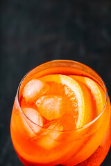 Glass of Aperol Spritz cocktail on a dark background. Aperol spritz cocktail with oranges and ice...