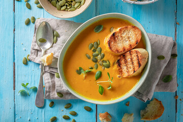 Healthy pumpkin soup served with toasted bread.