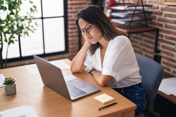 Young hispanic woman business worker stressed using laptop at office