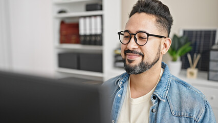 Young latin man business worker using computer working at office