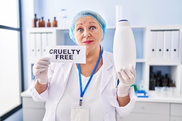 Middle age caucasian woman working on cruelty free laboratory clueless and confused expression. doubt concept.